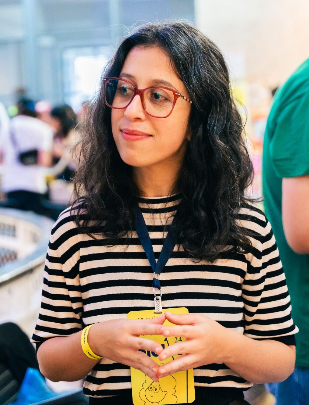 Retrato de Rachel Paterman na banquinha Academicomics em feira de quadrinhos. Desorientanda desenhada no crachá